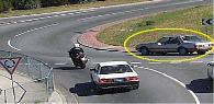 category intersections - The motorcyclist wants to travel straight ahead through this roundabout. The rider should watch out for the marked car because the car: